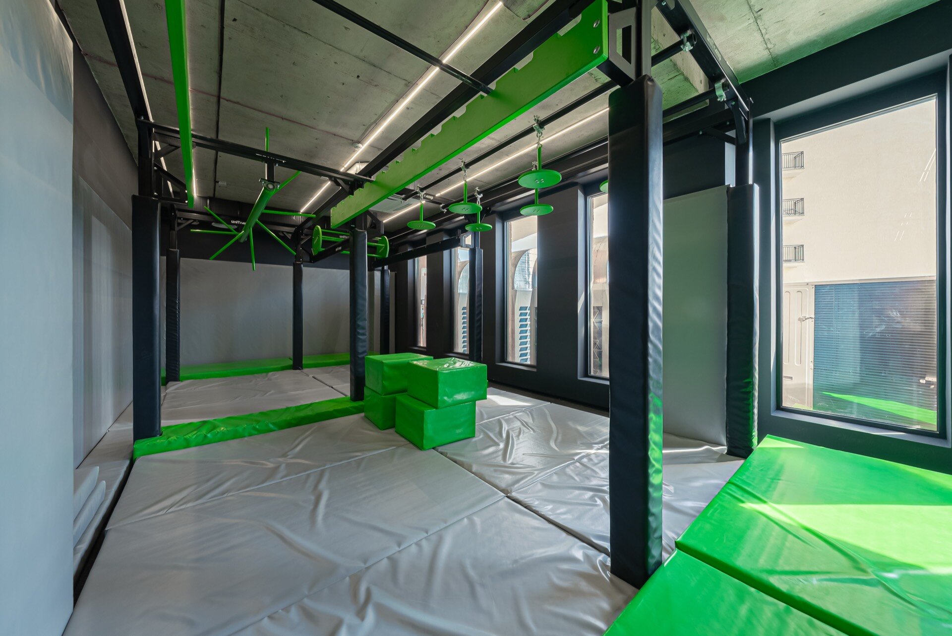 Indoor Jungle Gym hall with climbing wall, soft mats, and obstacles at Gymnasia.