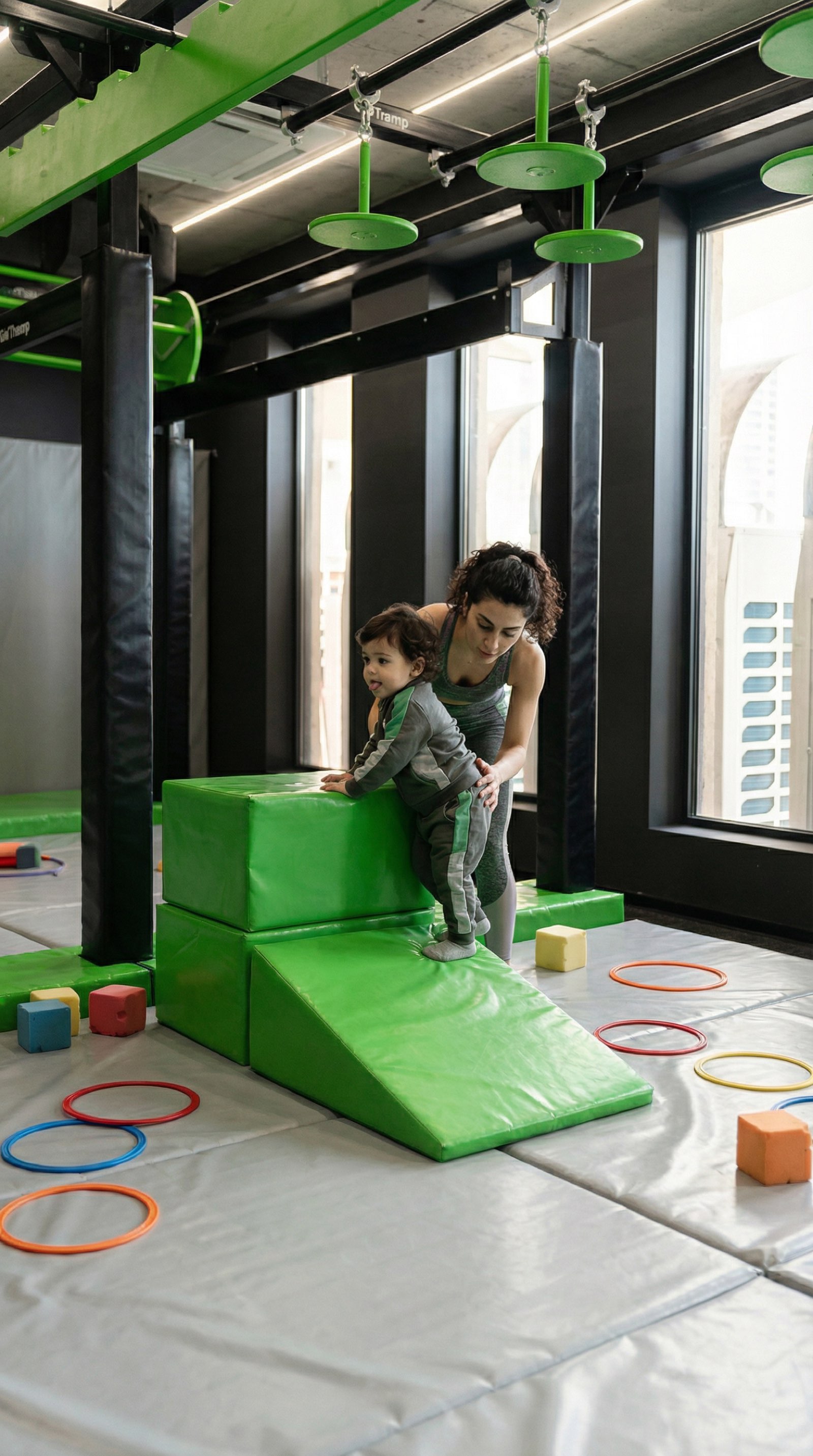 Toddler climbing soft Jungle Gym blocks supported by a Gymnasia coach.